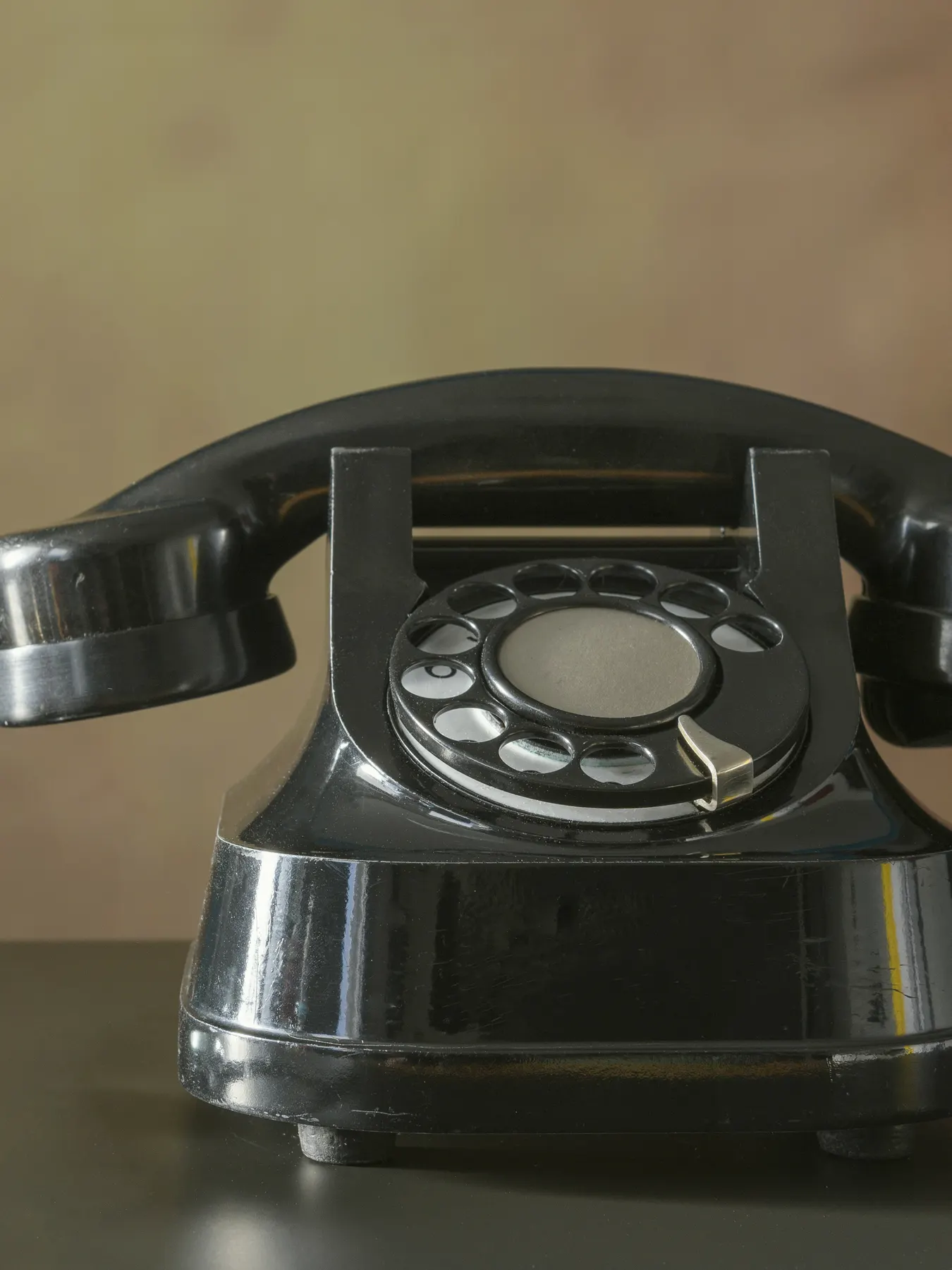Stary telefon z tarczą na drewnianym blacie, ciepłe światło w tle — czasem najszybciej po prostu zadzwonić